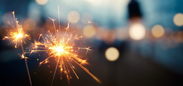 Close-up of a lit sparkler with bright sparks, evoking a festive mood—suited for workers’ compensation mediation events.