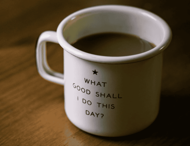 A white coffee mug rests on a wooden table, evoking ideas of legal mediation services and a productive day ahead.
